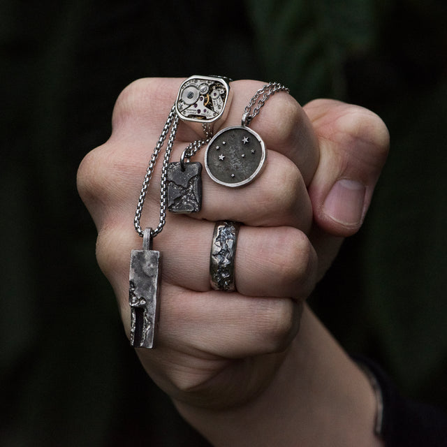 carved band silver ring on a finger