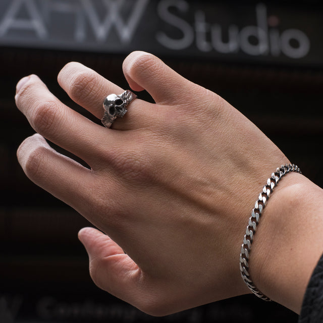 silver skull ring on a finger